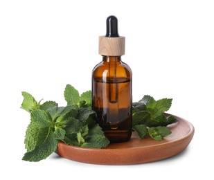 Photo of Bottle of essential oil and mint isolated on white