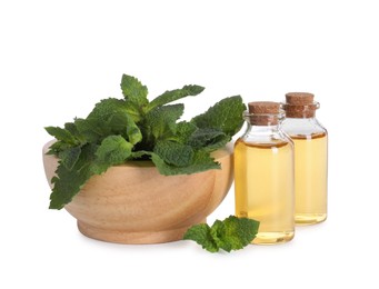 Bottles of essential oils and mint isolated on white