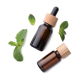 Bottles of essential oils and mint isolated on white, top view