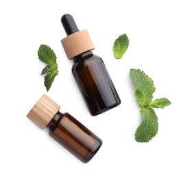 Photo of Bottles of essential oils and mint isolated on white, top view