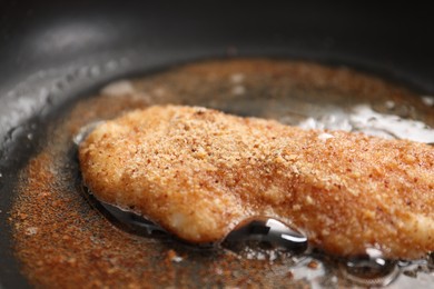 Cooking schnitzel in frying pan on stove, closeup