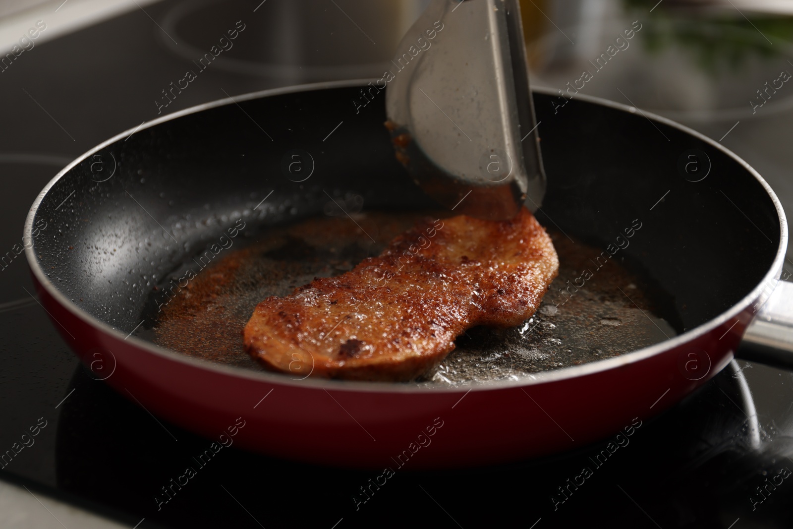 Photo of Cooking schnitzel in frying pan on stove, closeup