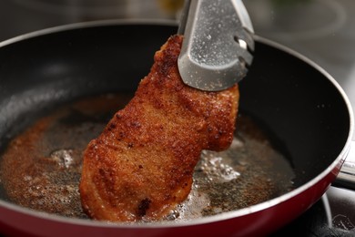 Cooking schnitzel in frying pan on stove, closeup