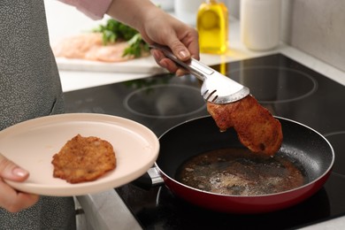 Woman cooking schnitzel in frying pan on stove, closeup