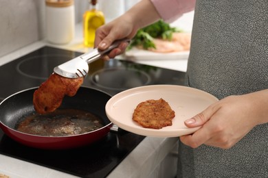 Woman cooking schnitzel in frying pan on stove, closeup