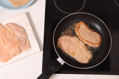 Cooking schnitzel in frying pan on stove, closeup