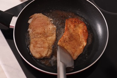 Photo of Schnitzels cooking in frying pan on stove, top view