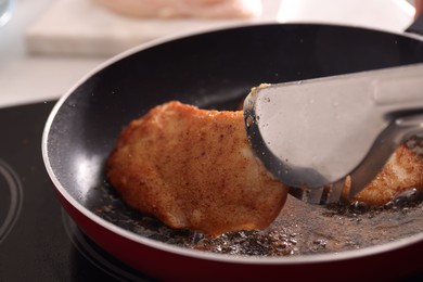 Schnitzels cooking in frying pan on stove, closeup