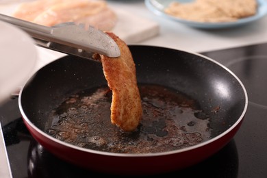 Cooking schnitzel in frying pan on stove, closeup