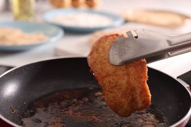 Photo of Cooking schnitzel in frying pan on stove, closeup