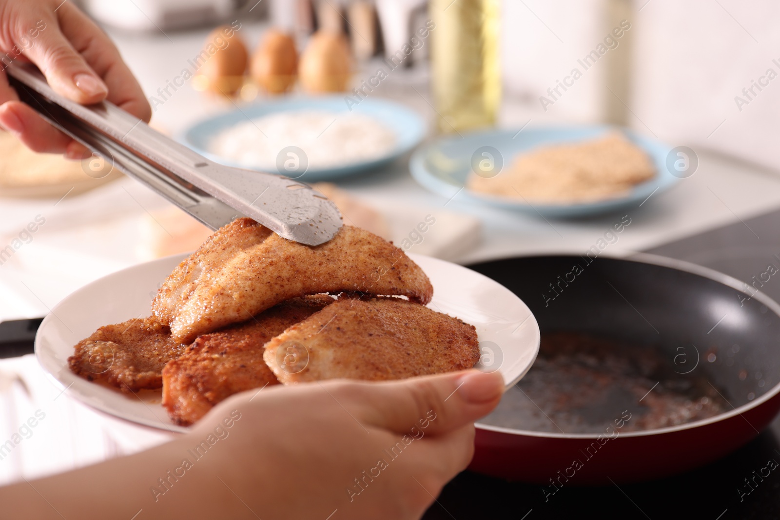 Photo of Woman cooking schnitzels in frying pan on stove, closeup