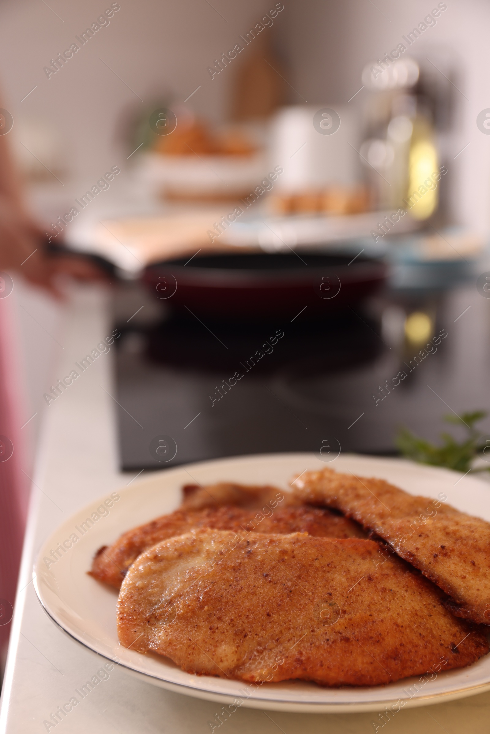 Photo of Plate of tasty schnitzels on table in kitchen, closeup