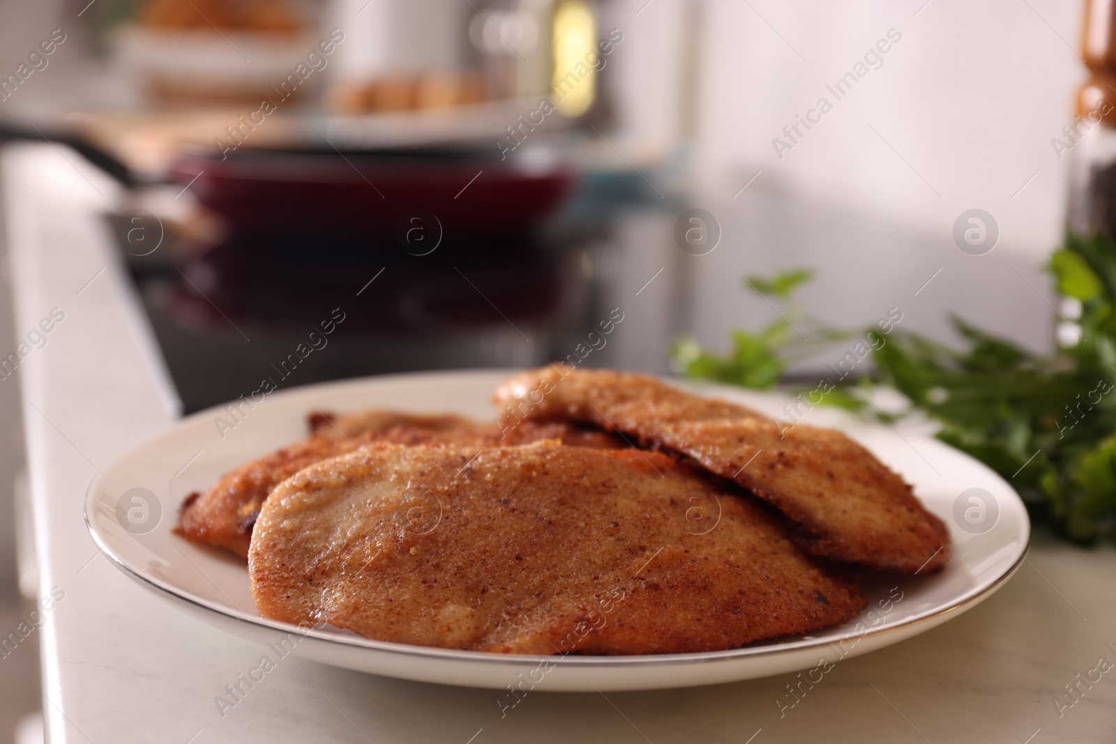 Photo of Plate of tasty schnitzels on table in kitchen, closeup