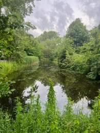 Photo of Picturesque view of canal and green trees