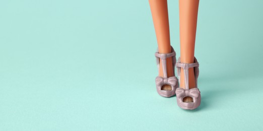 Image of Doll's legs with fancy shoes on turquoise background, banner design. Space for text