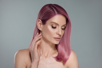 Image of Attractive woman with pink hair on grey background