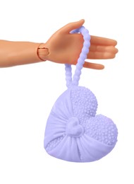 Doll's hand with bag in shape of heart on white background