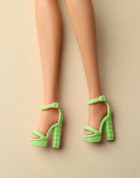 Image of Doll's legs with fancy shoes on beige background