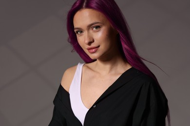 Image of Beautiful young woman with pink on grey background