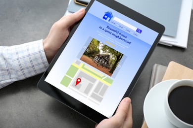 Man choosing dwelling on house hunting website via tablet at table, closeup