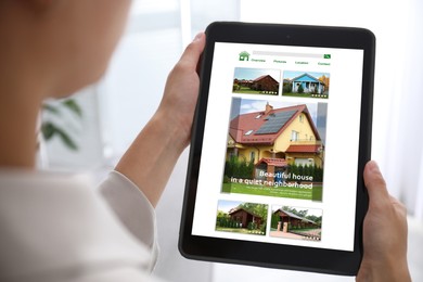 Image of Woman choosing dwelling on house hunting website via tablet indoors, closeup