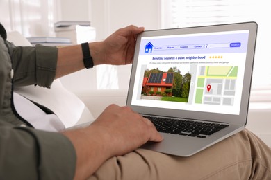 Man choosing dwelling on house hunting website via laptop at home, closeup