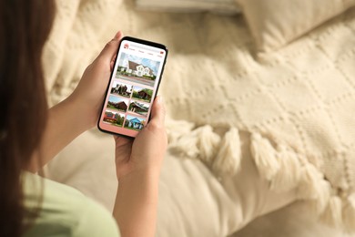 Image of Woman choosing dwelling on house hunting website via smartphone indoors, closeup