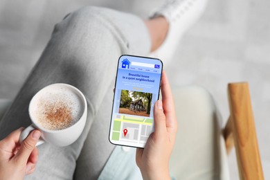 Woman choosing dwelling on house hunting website via smartphone indoors, closeup