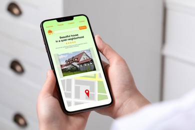 Image of Woman choosing dwelling on house hunting website via smartphone indoors, closeup