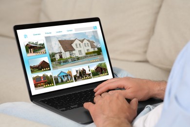 Image of Man choosing dwelling on house hunting website via laptop indoors, closeup