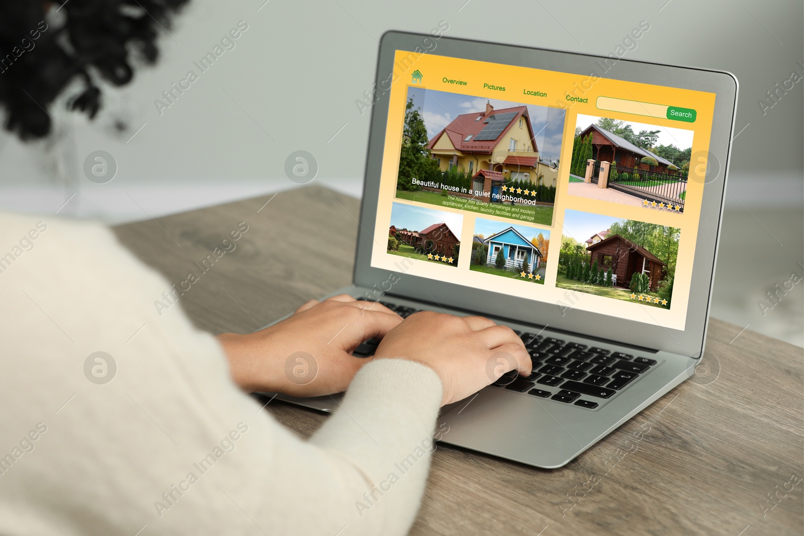 Image of Woman choosing dwelling on house hunting website via laptop at table, closeup