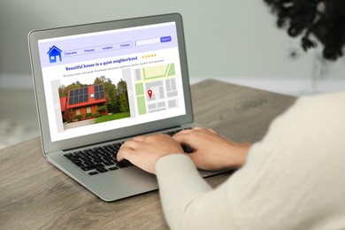 Woman choosing dwelling on house hunting website via laptop at table, closeup