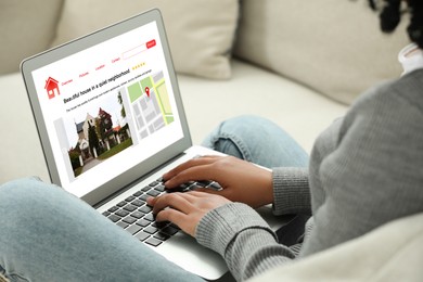 Image of Woman choosing dwelling on house hunting website via laptop indoors, closeup