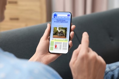 Image of Woman choosing dwelling on house hunting website via smartphone indoors, closeup