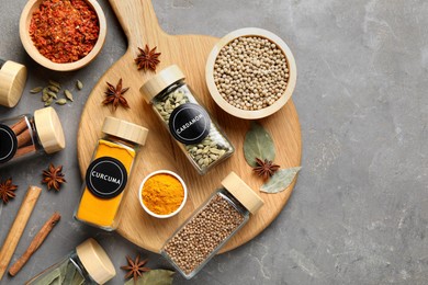 Image of Labelled jars with spices on grey table, flat lay