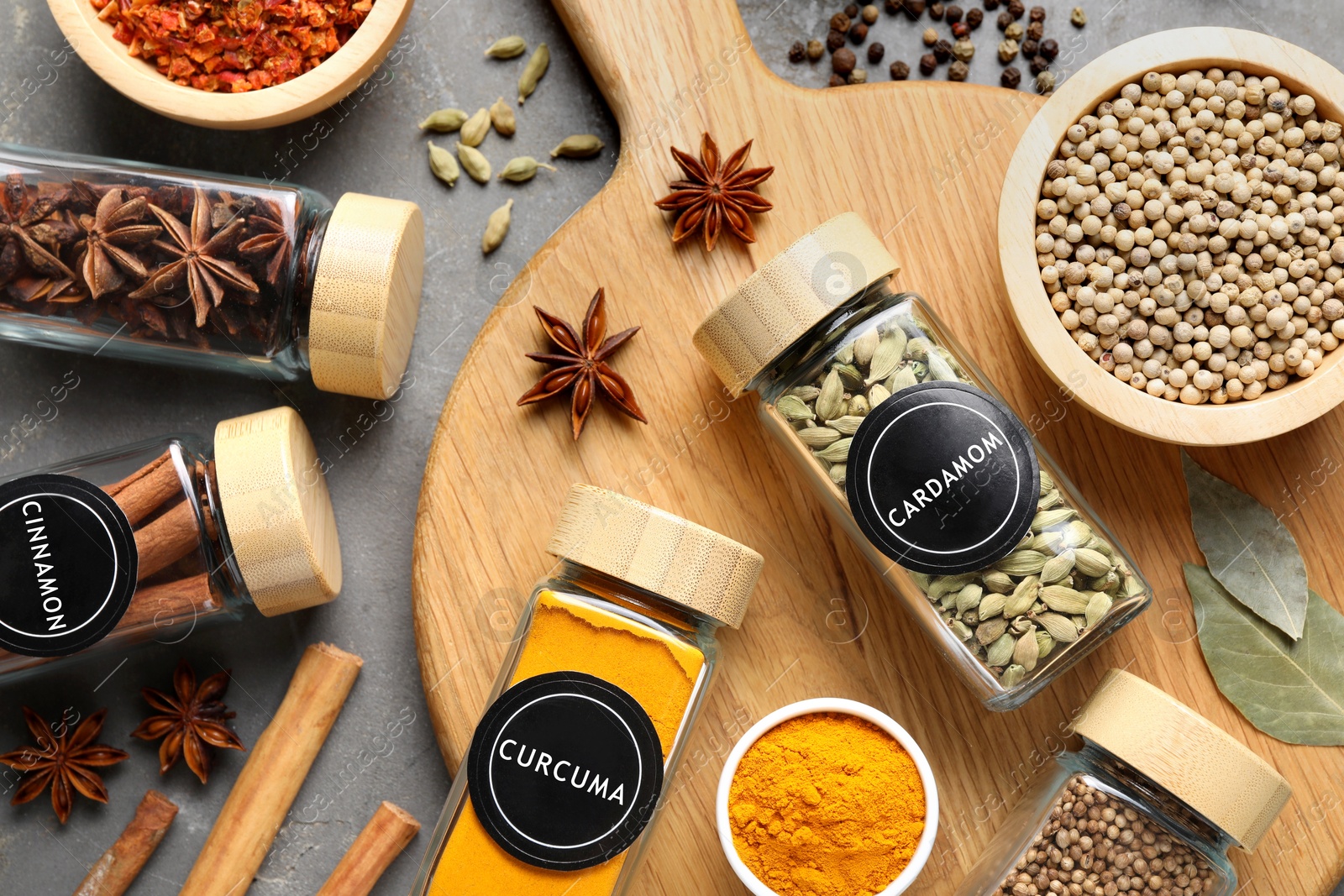 Image of Labelled jars with spices on grey table, flat lay