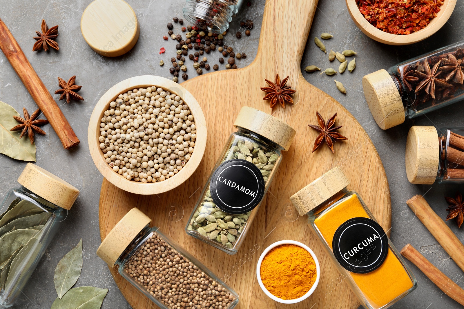 Image of Labelled jars with spices on grey table, flat lay