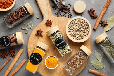 Image of Labelled jars with spices on grey table, flat lay