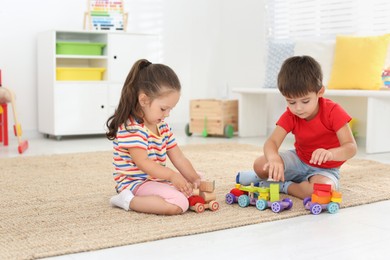 Cute little children playing with toys on floor at home