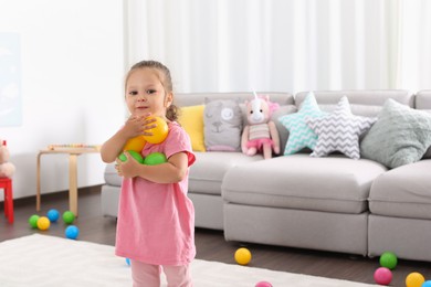 Cute little girl playing with toys at home