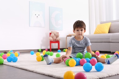 Photo of Cute little boy playing with toys on floor at home, space for text