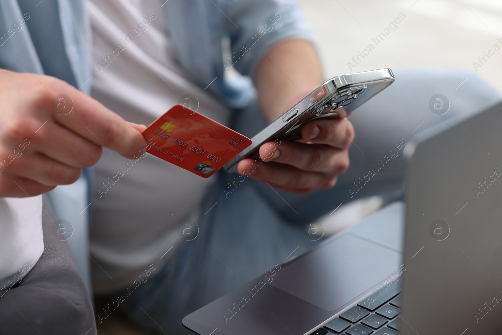 Photo of Online banking. Man with credit card and laptop paying purchase at home, closeup