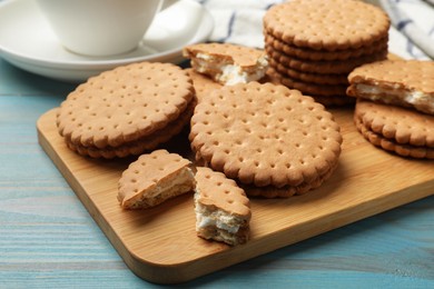 Tasty sandwich cookies on light blue wooden table, closeup