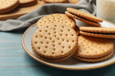 Photo of Tasty sandwich cookies on light blue wooden table, closeup