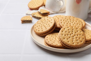 Photo of Tasty sandwich cookies on white table, closeup. Space for text