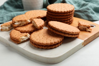 Photo of Tasty sandwich cookies on white table, closeup