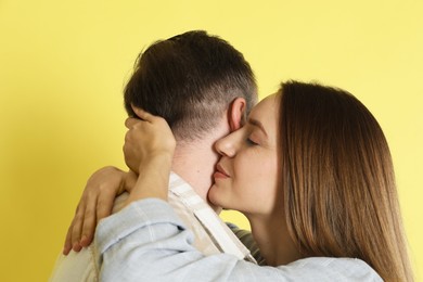 Photo of Woman hugging her boyfriend on yellow background