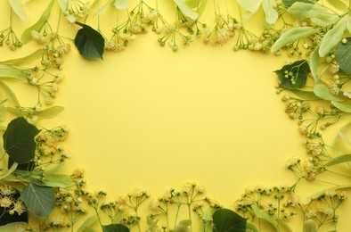 Fresh linden leaves and flowers on yellow background, top view. Space for text