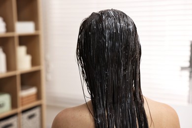 Photo of Woman with applied hair mask in bathroom, back view
