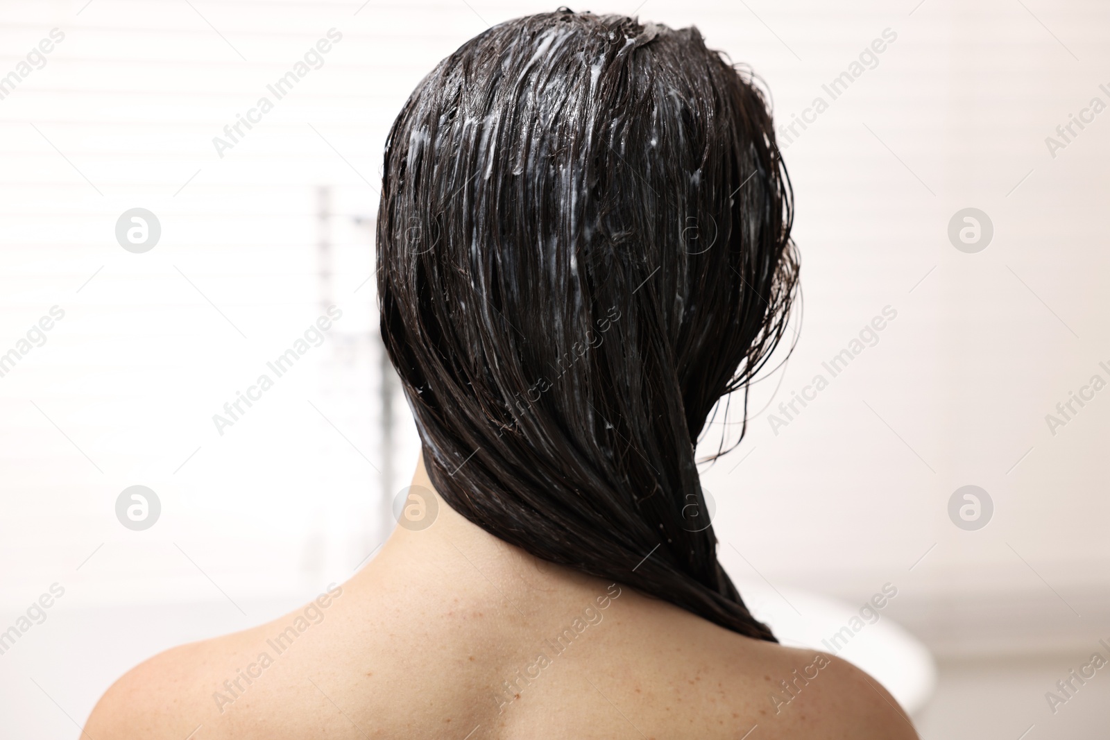 Photo of Woman with applied hair mask in bathroom, back view